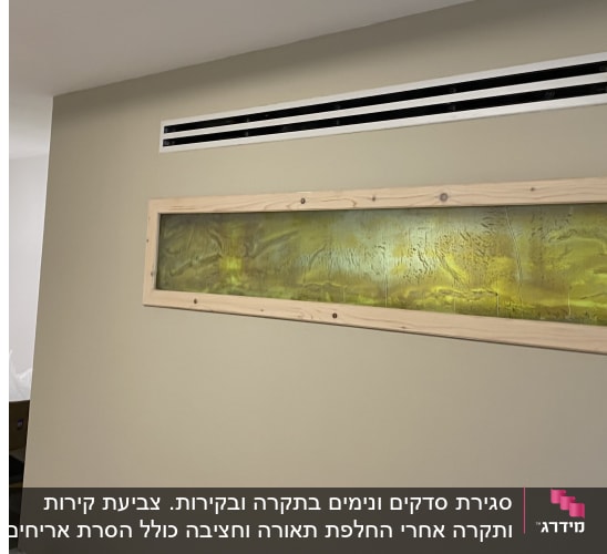 ציור מופשט בצבעים ירוק וצהוב במסגרת עץ